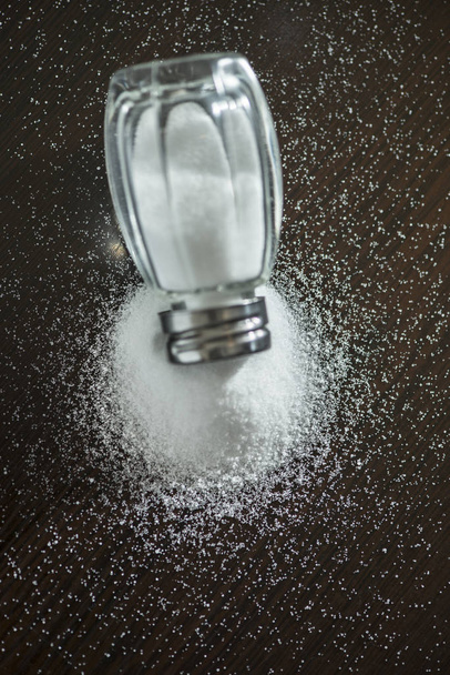Salt shaker on pile of salt - Фото, зображення