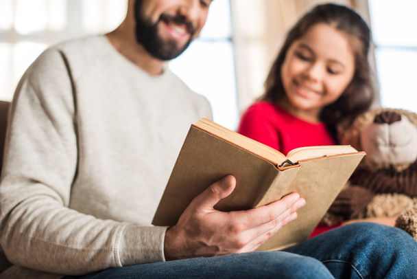 cropped image of father reading book to daughter - 写真・画像