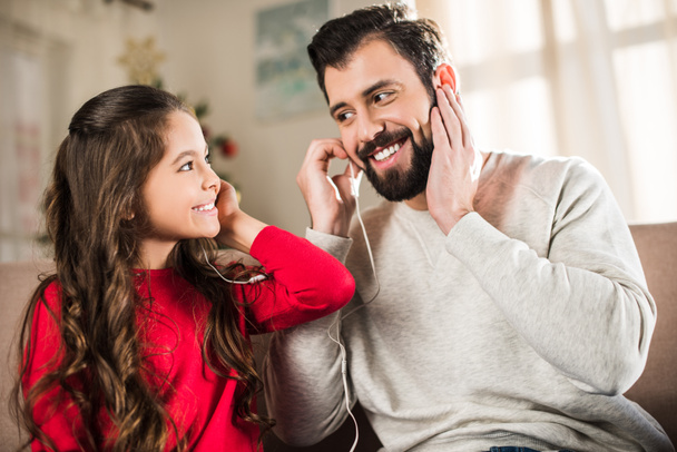 happy father and daughter listening to music with earphones - Photo, Image