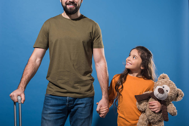 imagen recortada de la hija y el padre tomados de la mano en azul
  - Foto, Imagen