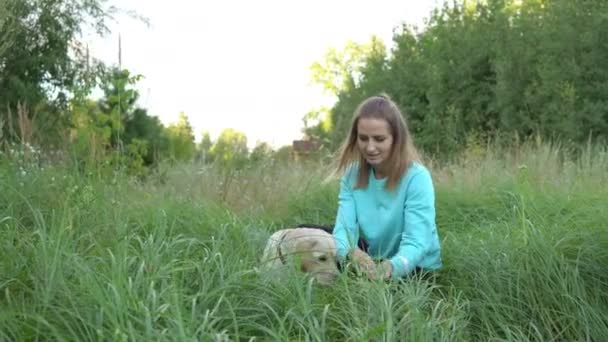 Młoda kobieta jest chodzenie z psem w lesie - Materiał filmowy, wideo