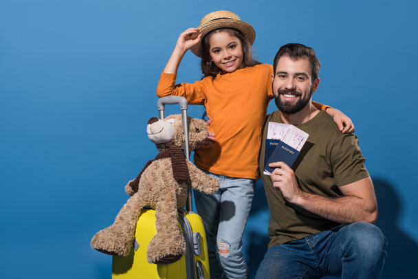 padre e hija con pasaportes y billetes que van a viajar en azul
 - Foto, Imagen