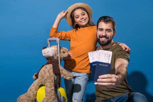 father and daughter with passports and tickets going on vacation on blue - Foto, Imagen