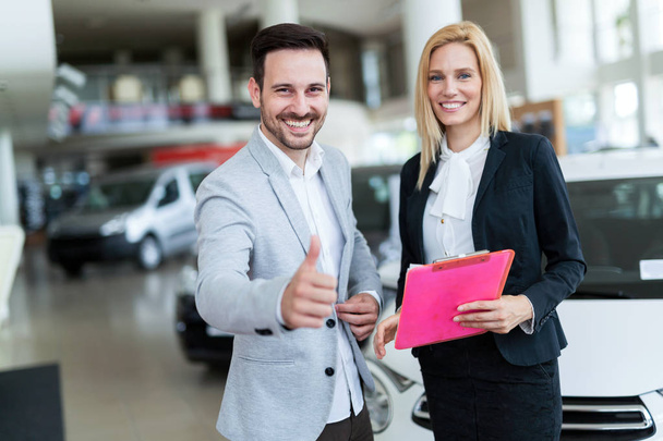 Professional salesperson selling cars  - 写真・画像
