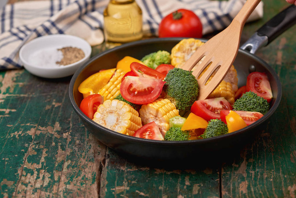 Fresh fruits and vegetables on a frying pan on an old wood background - Photo, Image