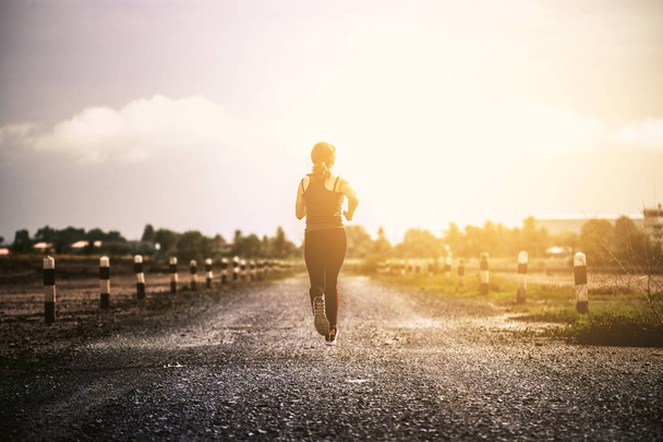 young fitness woman running on the road in the morning. - Photo, Image