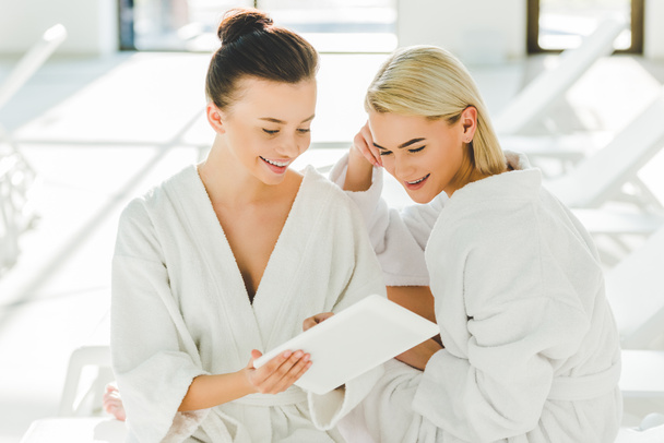 attractive young women using tablet at spa center - Фото, зображення