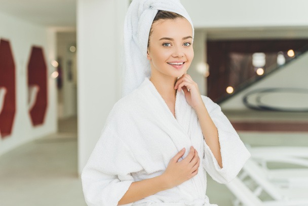 hermosa mujer joven en albornoz y toalla en la cabeza en el salón de spa
 - Foto, Imagen