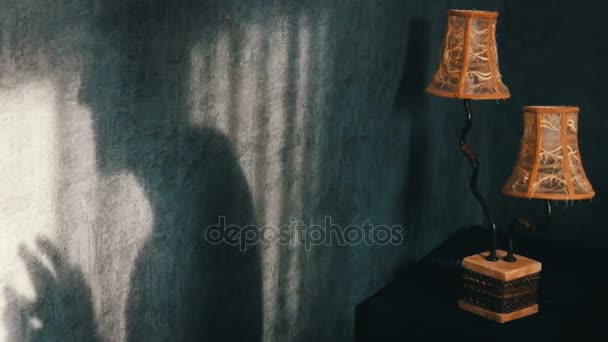 schrecklicher Schatten in einem gotischen dunklen Raum neben einer gelben Vintage-Lampe, bedrohlich fingernd. ein Gespenst oder eine Hexe zu Halloween. - Filmmaterial, Video