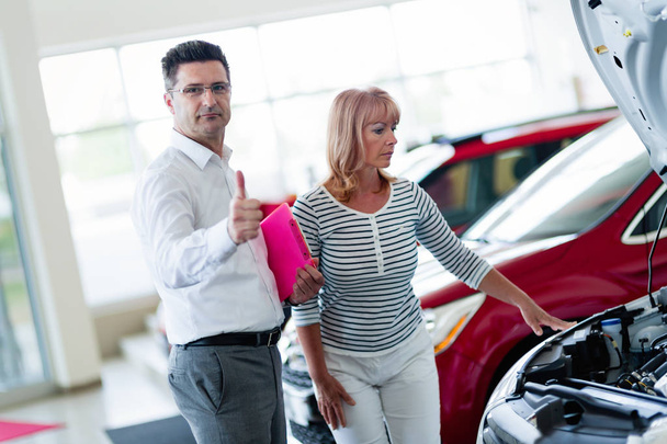 Customer looking at cars at dealership - Φωτογραφία, εικόνα