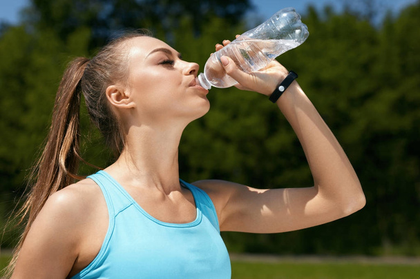 Frau trinkt Wasser nach dem Laufen. - Foto, Bild