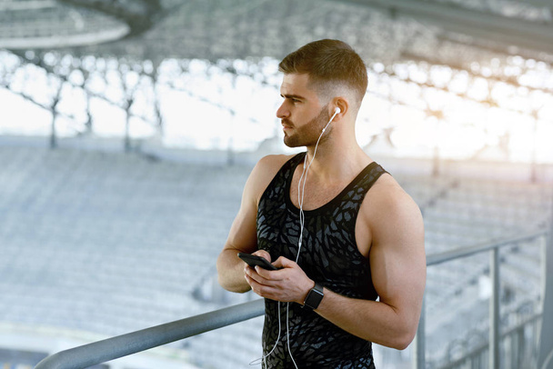 Homem ouvindo música no telefone durante o exercício ao ar livre
. - Foto, Imagem