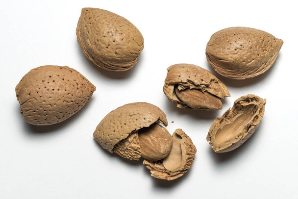 Whole and broken almonds on white background - Photo, Image