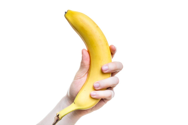 Κρατώντας μια μπανάνα στο χέρι σε λευκό φόντο - Φωτογραφία, εικόνα