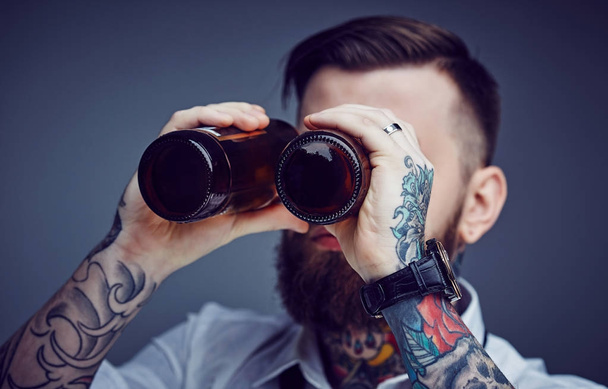 Un hombre mirando entre botellas de cerveza
. - Foto, imagen