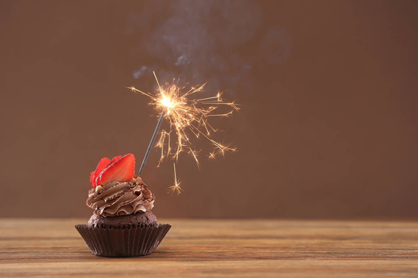 Tasty chocolate cupcake with sparkler  - Foto, afbeelding