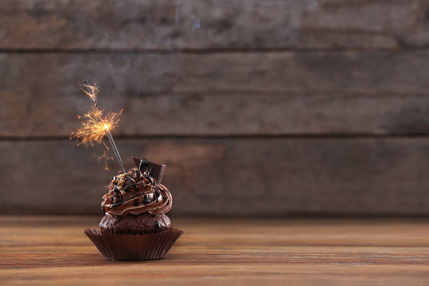 Tasty chocolate cupcake with sparkler  - Φωτογραφία, εικόνα