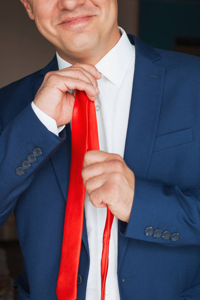 El hombre endereza su corbata
 - Foto, Imagen