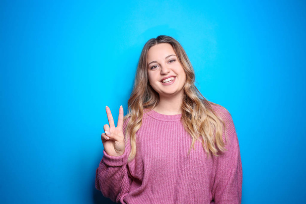 Young smiling woman on color background - Valokuva, kuva