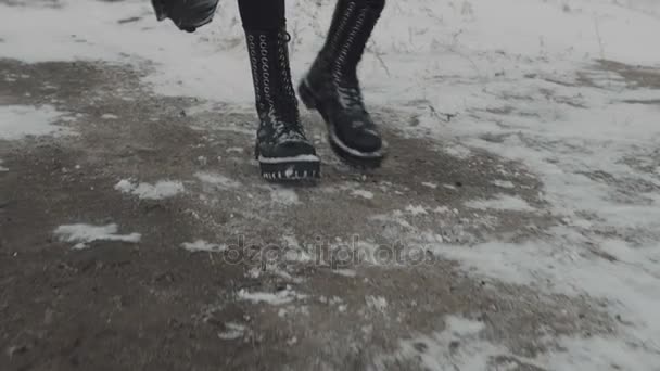Chodzenie w czarne spodnie i buty czarny rock. Snow ziemią - Materiał filmowy, wideo