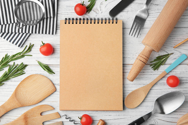 Notebook and various kitchen utensils on wooden background - Фото, зображення