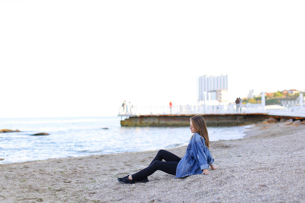 Gyönyörű fiatal nő ül a strandon ellazítja, és élvezi Nézd o - Fotó, kép