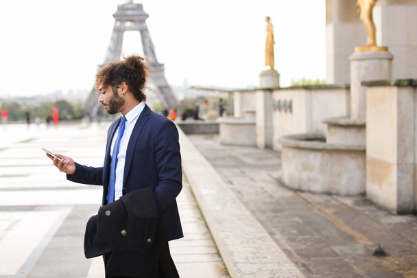 Muszlim fiú flörtöl barátnője smartphone közelében Eiffel által - Fotó, kép
