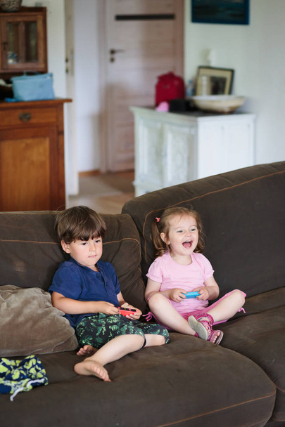 Kleine jongen en meisje spelen video game - Foto, afbeelding