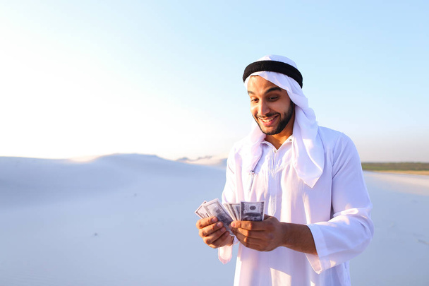 Onnistunut arabi sheikki pitää seteleitä ja onnellinen, pysyvä i
 - Valokuva, kuva