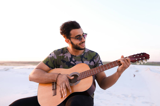 Arap yakışıklı genç gitar mi Hill'de oturan, ayarlar - Fotoğraf, Görsel