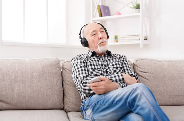 Senior man listening to music with headphones - Фото, зображення
