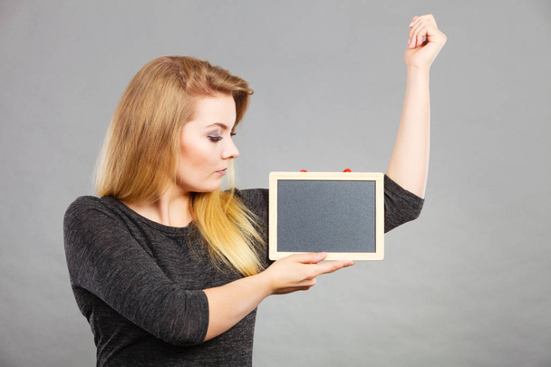 Woman holding blank black board under armpit - Foto, immagini