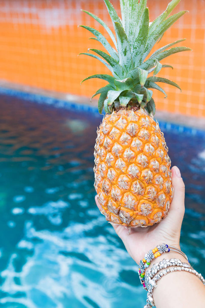 Fresh yellow pineapple tropic fruit summer in woman hands carryi - Valokuva, kuva