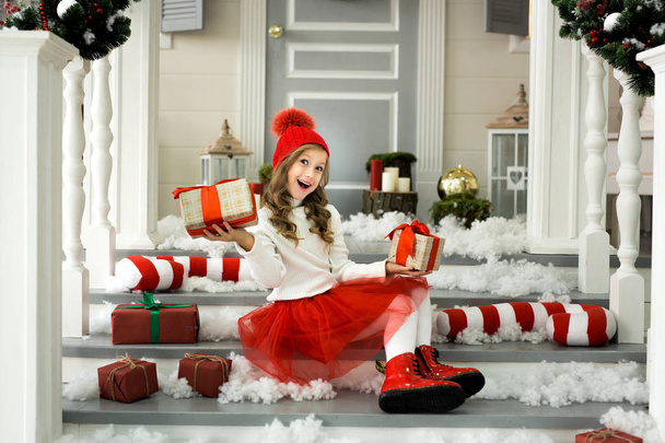 Happy little girl holding a lot of boxes with gifts. winter holidays, christmas and people concept. - Foto, Imagen
