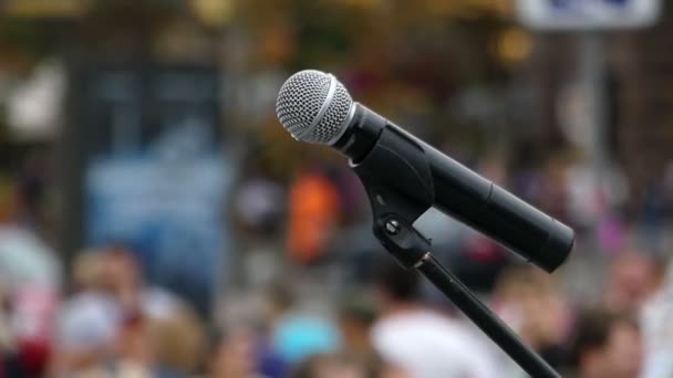 Un microphone moderne installé sur une place pleine de personnes
 - Séquence, vidéo