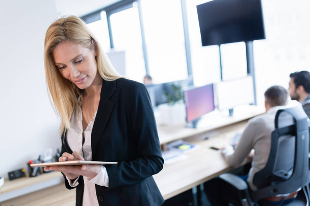 Beautiful businesswoman using digital tablet in modern office - Zdjęcie, obraz