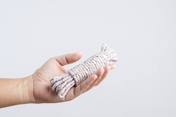 Hand holding parachute cord of nylon rope on white background - Fotografie, Obrázek
