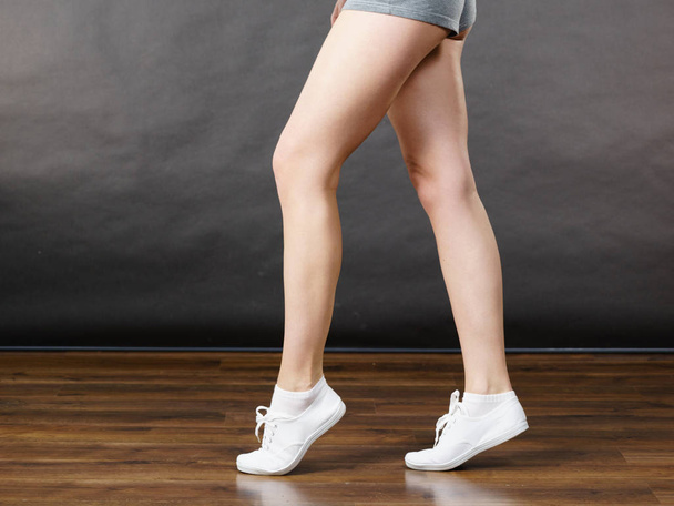 Woman wearing grey shorts, legs only - Foto, imagen