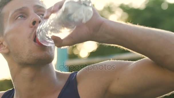 durstiger Sportler trinkt beim Training Wasser, schaut sich um, Zeitlupe - Filmmaterial, Video