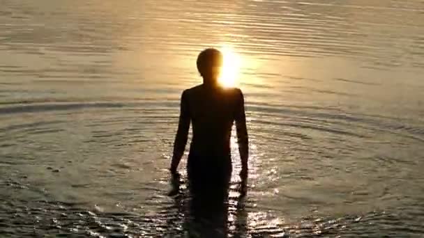 Splendido tramonto è sopra la testa di un uomo che si tuffa, salta e getta acqua
 - Filmati, video