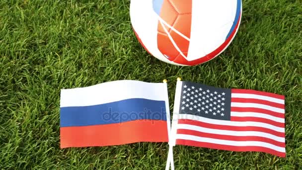 Fotbalový míč a vlajky Ruska a Spojených států. Fotbalový míč v trávě, světový pohár. - Záběry, video