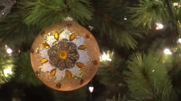 Concetto di stagione di saluto.Colpo di ornamenti su un grande albero di Natale con luce decorativa e neve che cade in 4k (UHD
) - Filmati, video