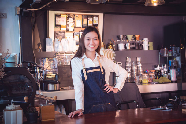 Beautiful barista standing and smiles in her cafe - Fotó, kép