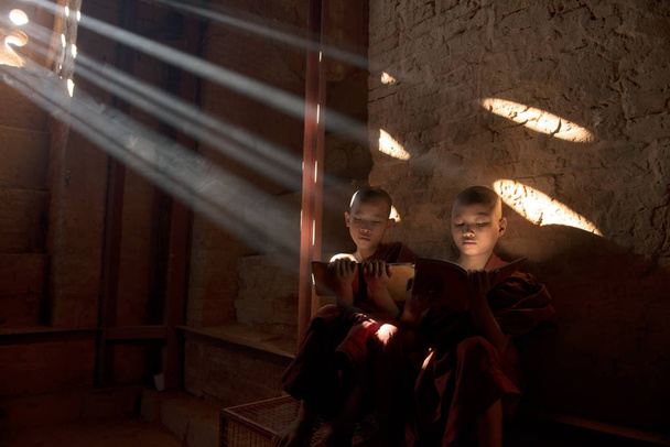 μοναχοί ανάγνωση στο μοναστήρι στις ακτίνες του ήλιου - Φωτογραφία, εικόνα