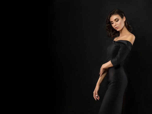 Young beautiful woman wearing black evening dress - Fotó, kép