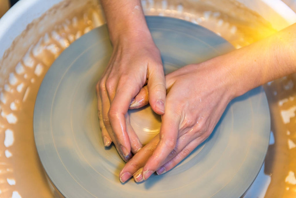 womens hands of a potter creating an earthen jar - Fotó, kép