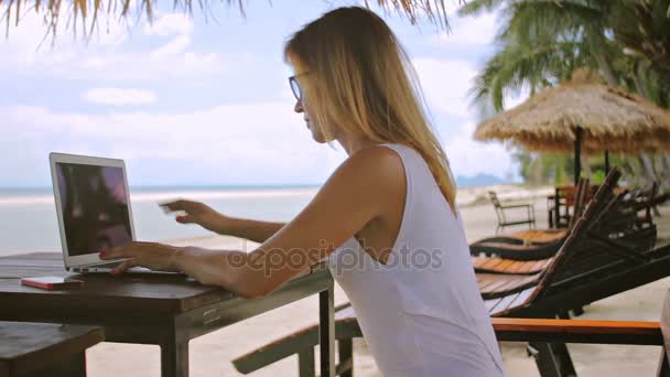Młoda kobieta siedzi w solarium z laptopa, 2 shos w freelancer - Materiał filmowy, wideo