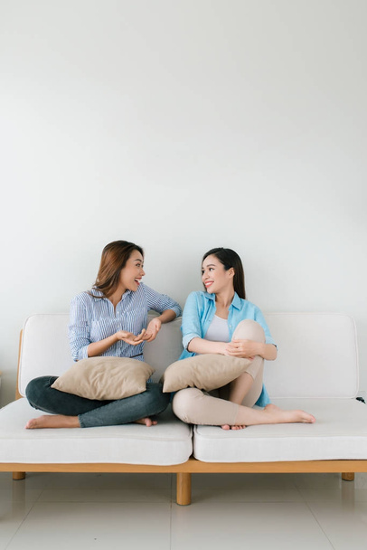 zwei Freundinnen unterhalten sich zu Hause auf der Couch - Foto, Bild
