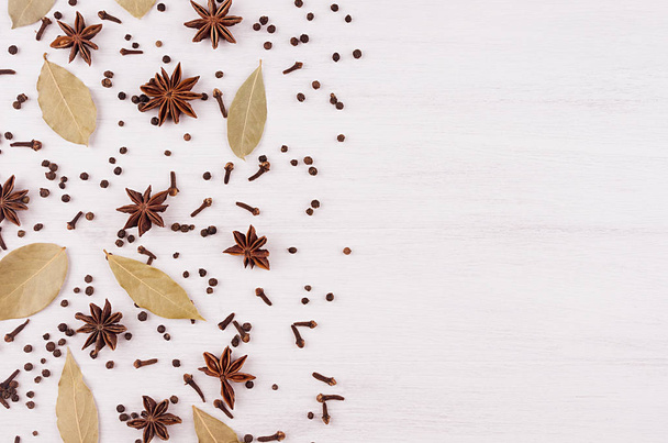 Anise stars, clove, bay leaves pattern on white wood background, copy space. - Photo, image