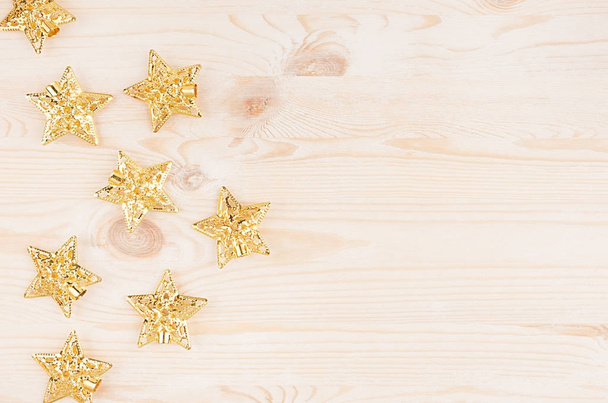 Gold stars on soft beige wooden background. Top view, copy space. - Foto, imagen